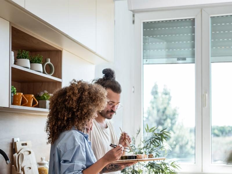 Couple dans une cuisine devant une fenêtre équipée d'un volet roulant bloc-baie LAKAL