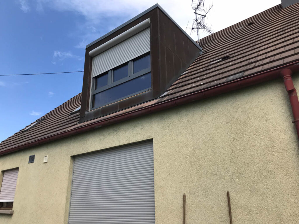 Maison avec chiens assis équipé d'une fenêtre avec volets roulants gris